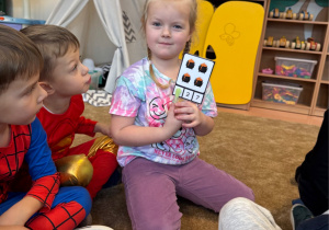 Dziewczynka wykonuje andrzejkowe zadanie