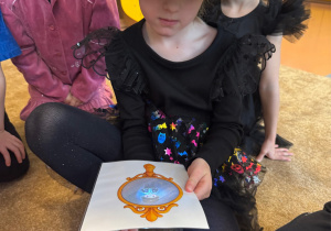 Dziewczynka świeci latarką w zabawie