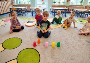 chłopiec sprawdza co jest pod kubeczkiem