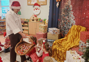 Pani Dyrektor rozdaje dzieciom czekoladowe mikołaje