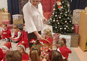 Pani Dyrektor rozdaje dzieciom czekoladowe mikołaje