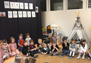 Dzieci siedzą na dywanie .