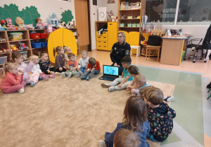 Przedszkolaki ogladają film edukacyjny o nie otwieraniu drzwi obcym.