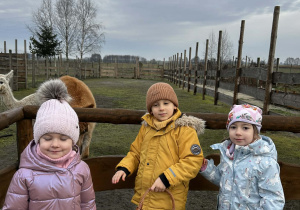Chłopiec i dwie dziewczynki pozują do zdjęcia