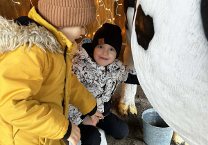 Chłopcy stoją przy krowie