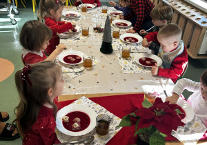 Dzieci siedzą przy wigilijnym stole