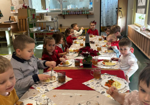Dzieci jedzą wigilijne potrawy