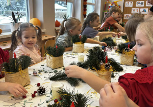 Dzieci wypełniają koszyczki dekoracjami świątecznymi