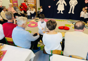 Chłopiec wręcza upominek swoim dziadkom