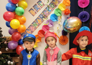 Chłopiec i dziewczynka pozują do zdjęcia na karnawałowej ściance