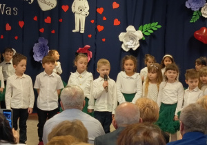 Dzieci recytują wiersze dla Babci i dziadka na tle dekoracji