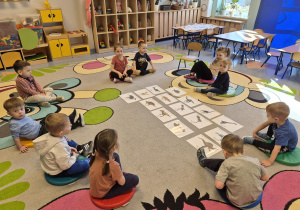 dzieci oglądają ilustracje dinozaurów