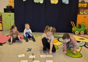 dziewczynka wskazuje właściwą liczbę dinozaurów