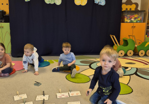 chłopiec przypina spinacz przy odpowiedniej liczbie dinozaurów