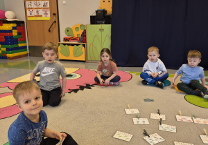przedszkolaki przypinają spinacze przy właściwych liczbach
