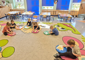 przedszkolaki układają pocięte dinozaury