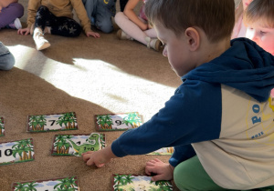 Chłopiec dopasowuje obrazek do odpowiedniego wyniku