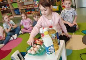 dzieci siedzą w kole i poznawają składniki na gofry