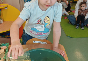 dziewczynka wlewa olej do miski