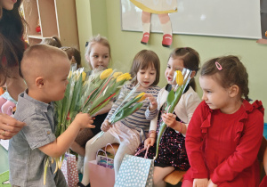 chłopiec wręcza dziewczynce kwiaty