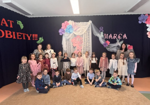 Zdjęcie grupowe na tle dekoracji z przedstawienia.