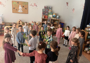 Taniec chłopców i dziewczynek w kole z kwiatami.