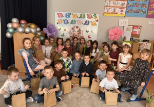 Zdjęcie grupowe na tle dekoracji w sali.